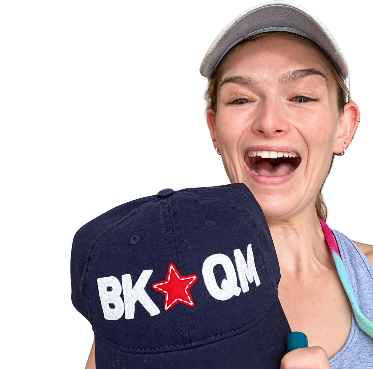 Kira smiling and holding the original navy BKQM hat with white lettering and a red star